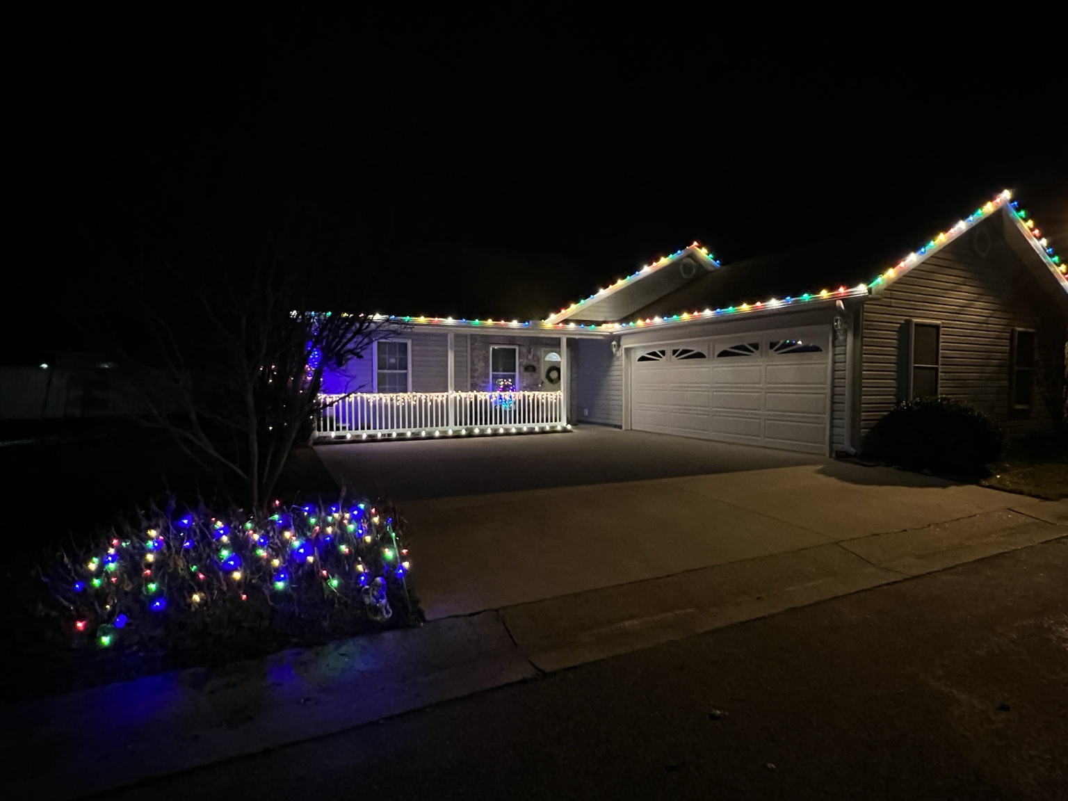 Multicolor holiday lights installed along a residential roofline