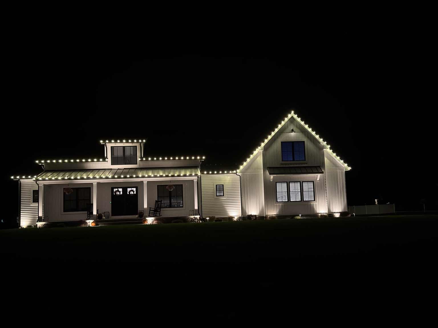 Permanent warm white roofline lights on a modern farmhouse