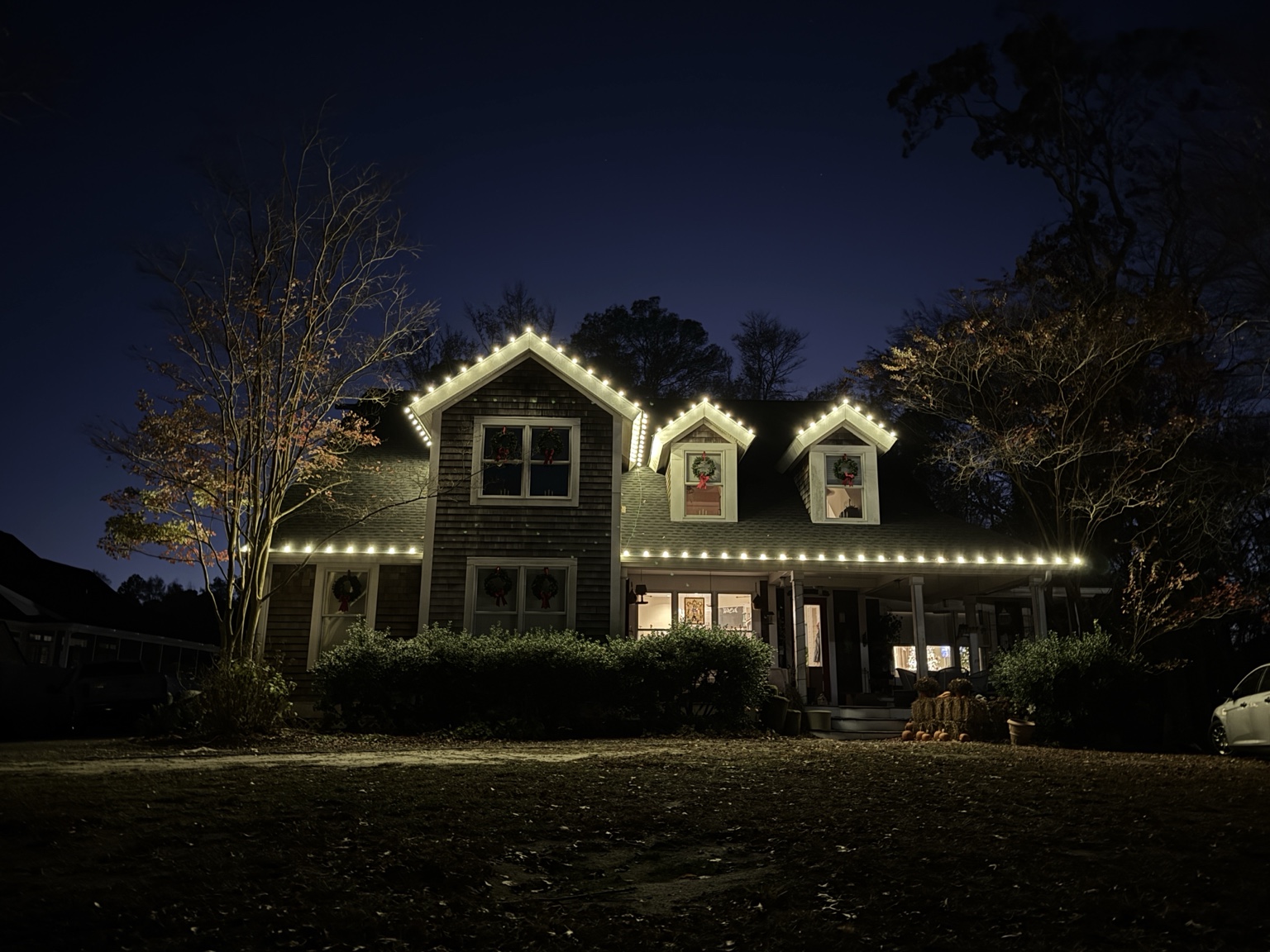 Warm white holiday lights outlining a traditional two-story home