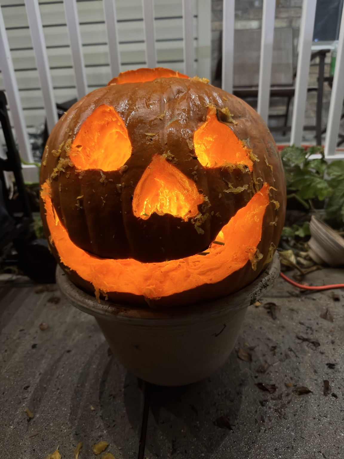Pretty Lit hand-carved pumpkin with sculpted eyes and a wide smile glowing orange